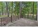 View of the back deck with wooden railing surrounded by a wooded lot at 220 Chinkapin Sw Cir, South Fulton, GA 30311