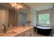 Bright bathroom featuring double vanity, soaking tub, and separate tiled shower at 4807 Greenway Rd, Norcross, GA 30071