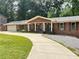 Traditional brick home boasts a long driveway and inviting curb appeal with a manicured lawn at 4807 Greenway Rd, Norcross, GA 30071
