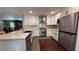 Modern kitchen featuring white cabinets, stainless steel appliances, and a breakfast bar overlooking the dining area at 4807 Greenway Rd, Norcross, GA 30071