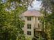 Exterior view of a multi-story home nestled among mature trees, featuring a private deck at 3801 Stonebriar Ln, Duluth, GA 30097