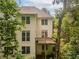 Multi-story home showcasing a private deck on the second floor, surrounded by mature trees at 3801 Stonebriar Ln, Duluth, GA 30097