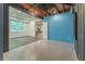 Open basement with neutral colored floors, blue accent wall, and open ceilings at 3801 Stonebriar Ln, Duluth, GA 30097