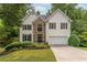 Charming two-story home with stone accents, black shutters and lush green landscaping at 3801 Stonebriar Ln, Duluth, GA 30097