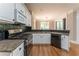 Close up of kitchen with stainless appliances, granite counters, and hardwood floors at 3801 Stonebriar Ln, Duluth, GA 30097