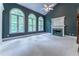 Bright living room with a fireplace and arched windows overlooking a wooded area at 3801 Stonebriar Ln, Duluth, GA 30097