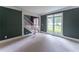Bright living room showcasing large windows, carpet floors and dark green walls at 3801 Stonebriar Ln, Duluth, GA 30097