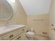 Half bath features a vanity with cream cabinets and a round mirror at 460 Chowning Nw Pl, Marietta, GA 30064