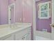 Bathroom features a window, white cabinets, and a large mirror for a bright and clean aesthetic at 460 Chowning Nw Pl, Marietta, GA 30064