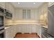 U-shaped kitchen with stainless steel appliances, white cabinets, and tile backsplash at 460 Chowning Nw Pl, Marietta, GA 30064