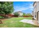 Wide view of the back yard featuring a green lawn, retaining wall, wooden fence and patio area at 726 Independence Ln, Acworth, GA 30102