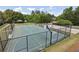 Outdoor community basketball court surrounded by a fence, benches, and lush trees on a sunny day at 726 Independence Ln, Acworth, GA 30102
