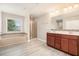 Modern bathroom with vanity, glass-door shower, bathtub, window, and a light wood grain floor at 726 Independence Ln, Acworth, GA 30102
