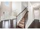 Entryway featuring hardwood floors, a carpeted staircase, wainscoting, and a decorative front door at 726 Independence Ln, Acworth, GA 30102