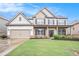 Charming two-story home featuring a manicured lawn, covered porch, brick accents, and an attached two-car garage at 726 Independence Ln, Acworth, GA 30102