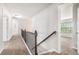 Bright hallway with carpet floors, metal railing, natural lighting, and access to various rooms at 726 Independence Ln, Acworth, GA 30102