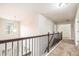 Bright hallway with carpet floors, metal railing, natural lighting, and access to various rooms at 726 Independence Ln, Acworth, GA 30102