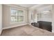 Carpeted living room with wainscoting, large window, and views of the decorative front door at 726 Independence Ln, Acworth, GA 30102