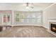 Open living room featuring a cozy fireplace, large windows, and neutral color scheme at 726 Independence Ln, Acworth, GA 30102