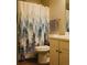 A bathroom with a white vanity, toilet, and a blue tree-themed shower curtain at 2350 Laurel Pointe Ln, Lawrenceville, GA 30043
