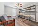 Cozy bonus room featuring gray walls, wood look flooring, custom shelving, and a futon at 2350 Laurel Pointe Ln, Lawrenceville, GA 30043