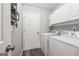 Bright laundry room features a modern washer and dryer, white cabinets, and organized storage at 2350 Laurel Pointe Ln, Lawrenceville, GA 30043