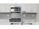 Close-up of a modern kitchen featuring stainless steel appliances and white cabinets at 3021 Cambridge Mill St, Acworth, GA 30102