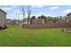 Picture of backyard surrounded by wooden fence in neighborhood. Lots of green grass and sky at 577 Joneus Dr, Mcdonough, GA 30252