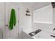Modern bathroom features soaking tub with a shelf and green towel hanging on the door at 577 Joneus Dr, Mcdonough, GA 30252