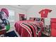 Bright bedroom with Atlanta Falcons decor, featuring a bed with matching bedding and wall decorations at 577 Joneus Dr, Mcdonough, GA 30252