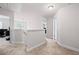 Upstairs hallway with neutral carpet, white walls and trim leading to various rooms at 577 Joneus Dr, Mcdonough, GA 30252