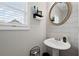 Cozy powder room features a white pedestal sink, oval mirror, and horizontally laid white tile at 577 Joneus Dr, Mcdonough, GA 30252