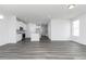 Open-concept living room with modern gray flooring, plenty of natural light, and a view into the kitchen at 801 York Aly, Acworth, GA 30102