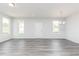 Spacious living room with gray floors, three large windows offering ample light, and a modern chandelier at 801 York Aly, Acworth, GA 30102