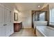 Bathroom featuring a glass-enclosed shower, soaking tub, tile floor, and a dark wood vanity at 1205 Apple Blossom Dr, Cumming, GA 30041