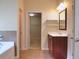 Bathroom with tile floor, single vanity, framed mirror, and soaking tub at 1205 Apple Blossom Dr, Cumming, GA 30041