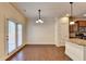 Eat-in kitchen and dining area with hardwood floors, slider doors, and a breakfast bar with granite counters at 1205 Apple Blossom Dr, Cumming, GA 30041