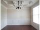 Dining room featuring elegant ceiling detail, classic wainscoting, and gleaming hardwood floors at 1205 Apple Blossom Dr, Cumming, GA 30041
