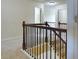 Hallway featuring neutral carpet and staircase with dark wood and iron railing at 1205 Apple Blossom Dr, Cumming, GA 30041