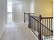Hallway featuring neutral carpet and staircase with dark wood and iron railing at 1205 Apple Blossom Dr, Cumming, GA 30041