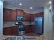 Kitchen with stainless steel appliances, granite countertops, and dark wood cabinets at 1205 Apple Blossom Dr, Cumming, GA 30041