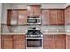 Kitchen featuring stainless steel oven and microwave and granite countertops over wood cabinets at 1205 Apple Blossom Dr, Cumming, GA 30041