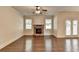 Open living room with hardwood floors, a stone fireplace, and natural light from the windows at 1205 Apple Blossom Dr, Cumming, GA 30041