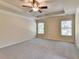 Spacious main bedroom featuring tray ceilings, ceiling fan, and natural light at 1205 Apple Blossom Dr, Cumming, GA 30041