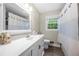 Classic bathroom with a white vanity, decorative mirror, and shower with blue-striped curtain at 2240 Murdock Rd, Marietta, GA 30062