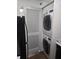 Convenient laundry room with stacked washer and dryer units next to a black refrigerator at 2479 Peachtree Ne Rd # 902, Atlanta, GA 30305