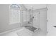 Modern tiled shower with glass enclosure, rainfall shower head, and patterned window at 3648 Sope Creek Farm Se, Marietta, GA 30067