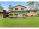 A two-story home with outdoor brick fireplace on the lattice-covered porch, and a spacious backyard at 423 Mephisto Cir, Lawrenceville, GA 30046