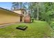View of home's lush green lawn, brick chimney, and garden area offering ample space for outdoor activities at 423 Mephisto Cir, Lawrenceville, GA 30046