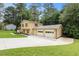 A two-story home featuring a two-car garage and long driveway, surrounded by lush greenery and lawn at 423 Mephisto Cir, Lawrenceville, GA 30046